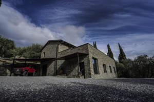 une maison en pierre avec un camion rouge garé devant elle dans l'établissement B&B il Pianolo, à Perinaldo