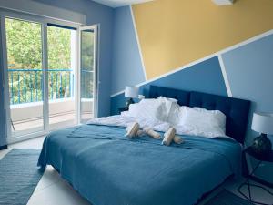 a blue bedroom with a blue bed with two wooden controllers at Hotel Elu Iris in Split