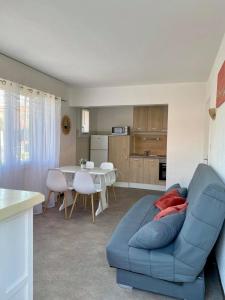 a living room with a blue couch and a table at La Maison Du Belvedere in Saint-Cyprien