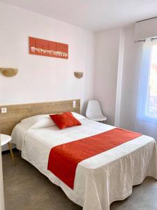 a bedroom with a large bed with a red blanket at La Maison Du Belvedere in Saint-Cyprien