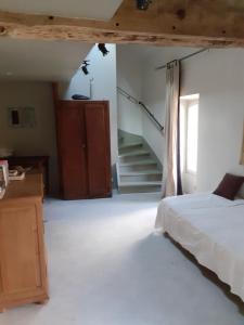 ein Schlafzimmer mit einem Bett und einer Treppe darin in der Unterkunft Ferme de la Basse-cour in Gommerville