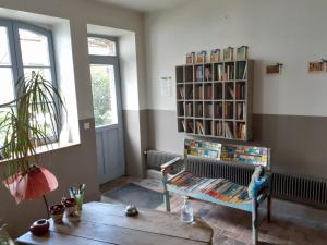 a living room with a book shelf with books at Ferme de la Basse-cour in Gommerville