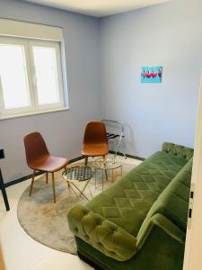 a living room with a green couch and chairs at Hotel Elu Iris in Split