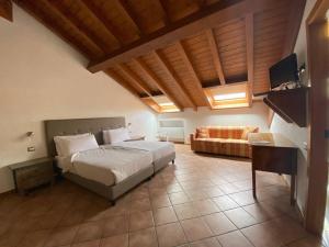 a large bedroom with a bed and a couch at Hotel Lenno in Lenno +57 photos