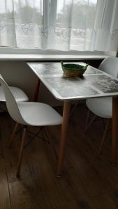 een tafel met twee stoelen en een kom erop bij Apartament 3-go Maja in Kartuzy
