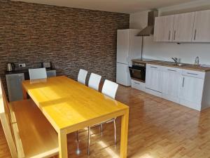 a kitchen with a wooden table and white cabinets at Dornbirn Hills, Watzenegg 45 in Dornbirn