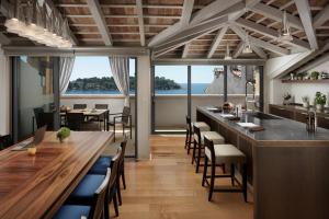 ロヴィニにあるMalipiero Residenceの海の景色を望む長いバーがあるレストラン