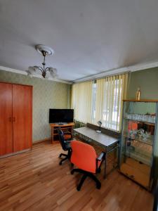 Cette chambre comprend un bureau, une table et des chaises. dans l'établissement Vienibas 38a, à Daugavpils