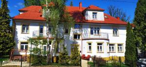 una grande casa bianca con tetto rosso di Parkowa Rezydencja Hubal a Rabka-Zdrój