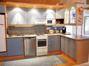 Una cocina con electrodomésticos de acero inoxidable y gabinetes de madera. en Sumppu 2, en Kalajoki 8 fotos más