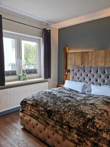 a bedroom with a large bed and two windows at Hotel am Kurpark in Bad Lauterberg