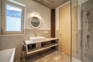 a bathroom with a sink and a mirror and a tub at Apartment Das Runde in Cermes +17 photos
