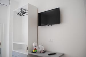 a living room with a tv on a white wall at B&B Le Palme in Diamante