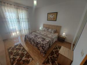 a small bedroom with a bed and a window at Bral Apartments 4 in Durrës