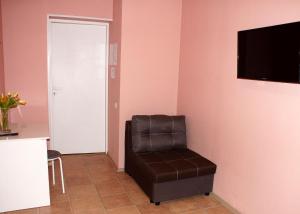 エカテリンブルクにあるAparts Letoの壁にテレビと椅子が備わる客室です。