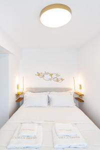 a bedroom with a white bed with two white pillows at Villa Dafni - Lindos in Lindos