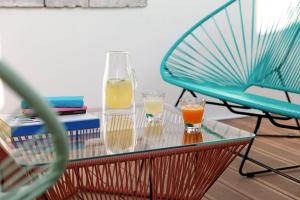 a glass table with two glasses of orange juice and a chair at Un Hôtel En Ville in La Rochelle