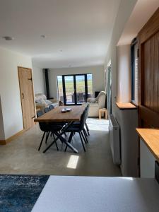 ein Esszimmer mit Tisch und ein Wohnzimmer in der Unterkunft Creber Cottage in Totnes
