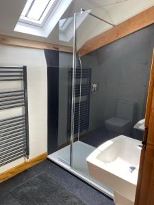 a bathroom with a glass shower and a sink at Creber Cottage in Totnes