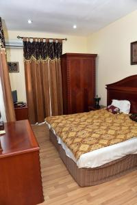- une chambre avec un lit et une table en bois dans l'établissement Ansera 55 Hotel Sheki, à Shaki