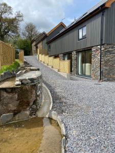 ein Haus mit Schotterstraße neben einem Gebäude in der Unterkunft Creber Cottage in Totnes