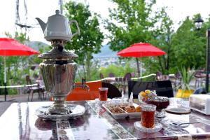 a table with a tea kettle and a plate of food at Ansera 55 Hotel Sheki in Sheki