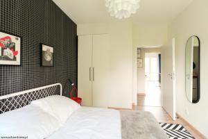 a bedroom with a white bed and a black wall at Gdynia Kamienna Góra in Gdynia