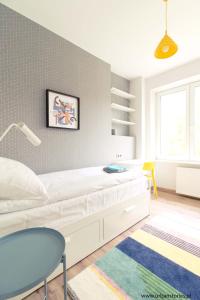 1 dormitorio con 1 cama blanca y 1 silla azul en Gdynia Kamienna Góra, en Gdynia