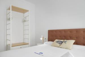 1 dormitorio con cama blanca y cabecero marrón en Etxaide - Basque Stay, en San Sebastián