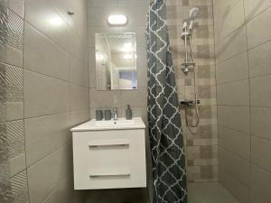 La salle de bains est pourvue d'un lavabo blanc et d'une douche. dans l'établissement ANITA B16 Studio Sunny Beach, à Sunny Beach