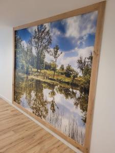 een groot schilderij van een meer in een kamer bij Hotel de Foreesten in Vierhouten