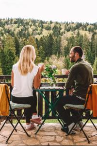 a man and a woman sitting at a table at Apartment Tarski konaci in Mitrovac
