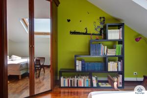a bedroom with green walls and a book shelf with books at T3 - l'Orangel - 3 étoiles - 70m2 - Vue mer - Saint-Denis in Saint-Denis