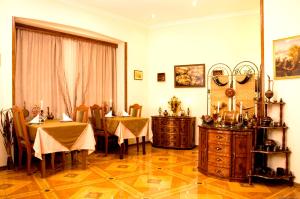 a dining room with two tables and a dresser at Hotel British House in Tbilisi City