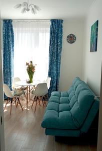 ヤンタルヌイにあるАпартаменты Yantarnaya Koronaのリビングルーム(青いソファ、テーブル付)