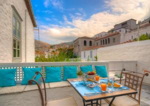 a patio with a table and chairs on a balcony at Cotommatae Hydra 1810 in Hydra