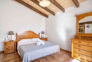 a bedroom with a bed and a dresser and a mirror at Es Camp Pla in Sineu