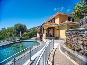 a house with a swimming pool in front of a house at OurMadeira - Quinta Girassol, countryside farmhouse in Ponta do Sol