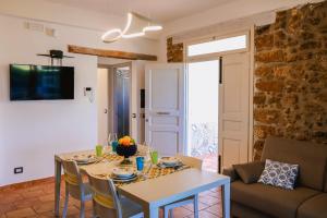 een woonkamer met een tafel en een bank bij Giardini Del Golfo in Balestrate