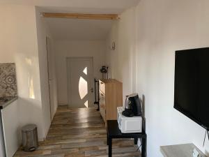 een kamer met een hal met een televisie en een tafel bij L’Ephemere Saint-Louis Maisonette in Marseille