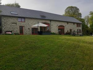 a stone building with a large yard in front of it at Auverg'Nature Chambre Auvergnate massage ayurvédique in Espinasse