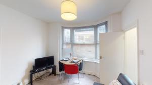 a living room with a small table and a television at The Rock Apartments II in London