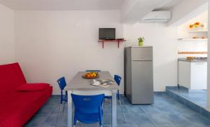 a kitchen with a table and blue chairs and a refrigerator at B&B Tor Di Lupo in Mattinata
