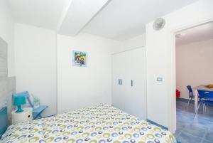 a white bedroom with a bed and a table at B&B Tor Di Lupo in Mattinata