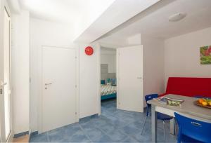 a kitchen and dining room with a red clock on the wall at B&B Tor Di Lupo in Mattinata