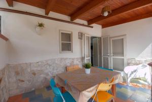 a table and chairs in a room with a stone wall at B&B Tor Di Lupo in Mattinata