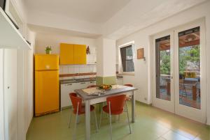a kitchen with a table and some orange cabinets at B&B Tor Di Lupo in Mattinata
