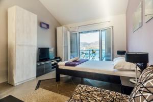 ein Schlafzimmer mit einem Bett und einem Balkon in der Unterkunft Beachfront Apartments Tivat in Tivat