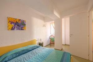 a bedroom with a bed and a painting on the wall at B&B Tor Di Lupo in Mattinata
