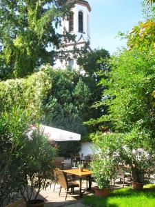 een patio met een tafel, stoelen en bomen bij Gasthaus Sonne Khaled Al Homsi in Vörstetten
